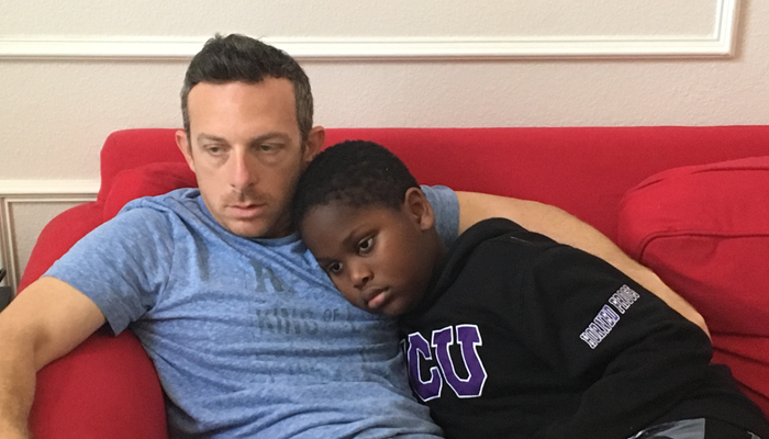 author Billy Cuchens and his son Jayden snuggle together at home