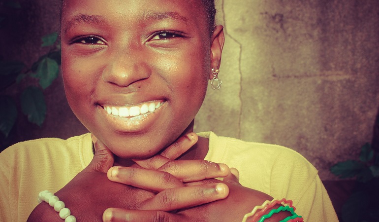 A girl who is part of a transracial family smiles at the camera