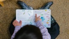 A boy reads an adoption children's book