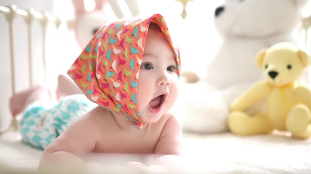 A baby smiles in her crib