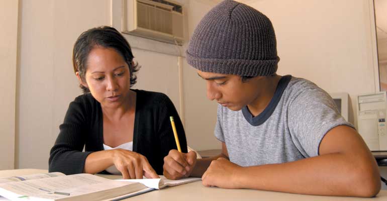 A teen works with a tutor to overcome learning problems
