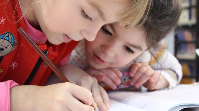 Two girls work together on a project during adoption classes.