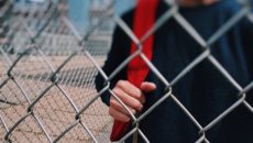 A boy walks into school, exhibiting typical adolescent behavior