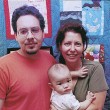 A family in front of their keepsake quilt