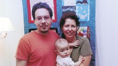 A family in front of their keepsake quilt