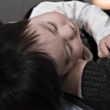 A parent holds his child after making an adoption announcement to his family.