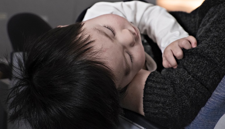 A parent holds his child after making an adoption announcement to his family.