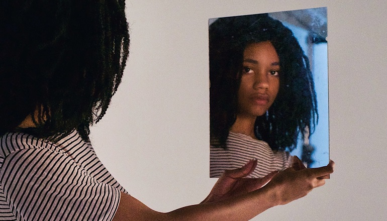 A preteen looks in the mirror as she wrestles with identity struggles