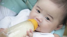 Picture of someone feeding their baby close to them, one of the ways to bond