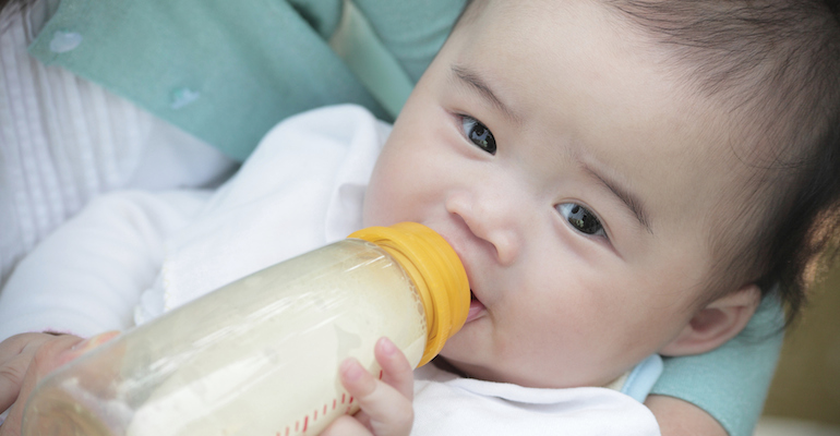 Picture of someone feeding their baby close to them, one of the ways to bond