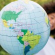 A child with a globe, representing a homeland trip