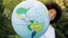 A child with a globe, representing a homeland trip