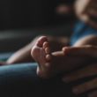 A woman holds her adopted baby after losing a child.