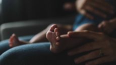 A woman holds her adopted baby after losing a child.