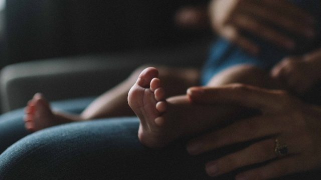 A woman holds her adopted baby after losing a child.