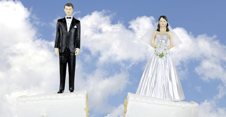 A wedding cake split in half showing adoption and divorce
