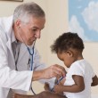 A doctor checking an African American baby for sickle cell anemia