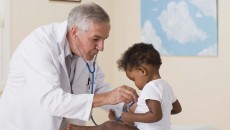 A doctor checking an African American baby for sickle cell anemia