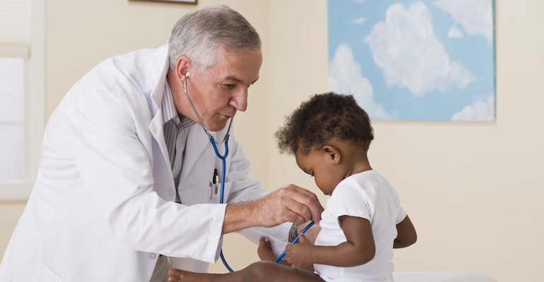 A doctor checking an African American baby for sickle cell anemia