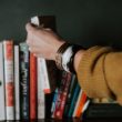 A woman picks up an adoption book from a bookshelf.