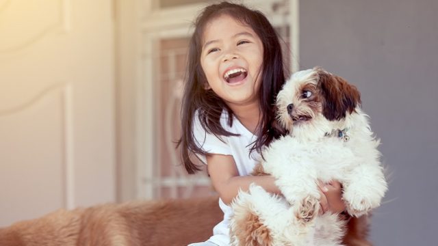 A girl laughs at her mom telling jokes for bonding with her child.