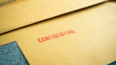 A file stamped, "Confidential" represents closed adoption records.