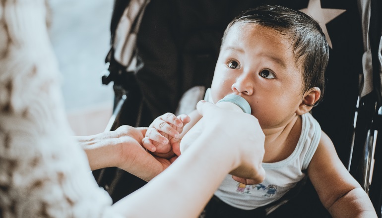 A mom feeds her son