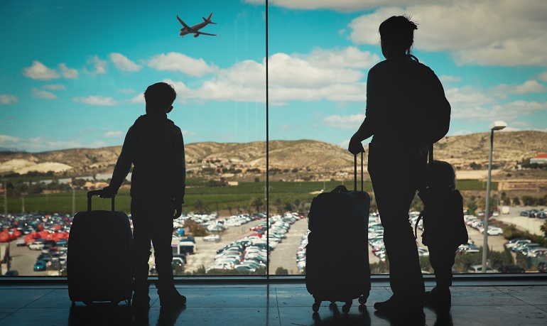 A mother and her kids at the airport, leaving for a heritage travel trip.