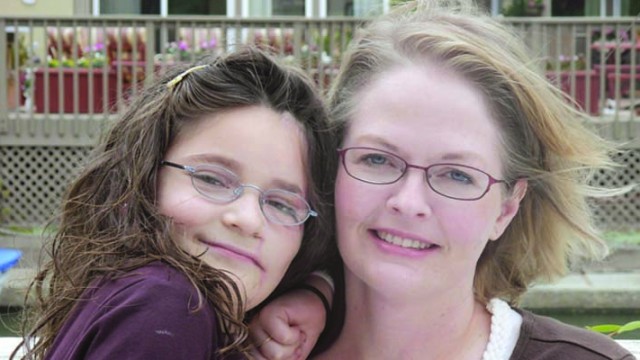 Anastasia, after her surgery to repair her facial burns, with her mother