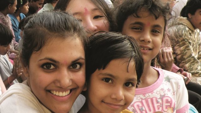 A woman embraces three children on a heritage travel trip to India