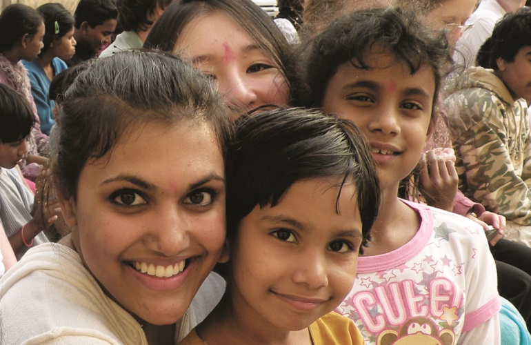 A woman embraces three children on a heritage travel trip to India