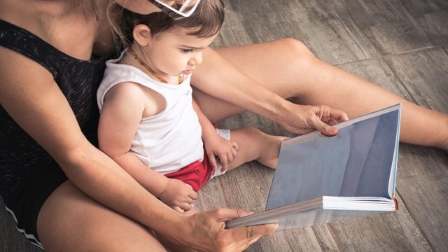 A mom works on language skills by reading with her child.