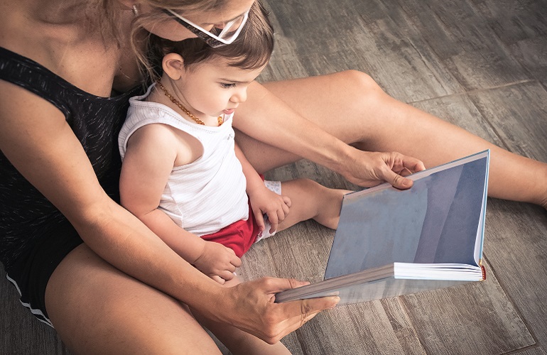 A mom works on language skills by reading with her child.