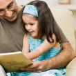 Father reading with his daughter to ward off language impairment