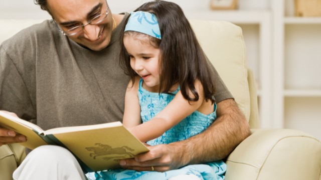 Father reading with his daughter to ward off language impairment