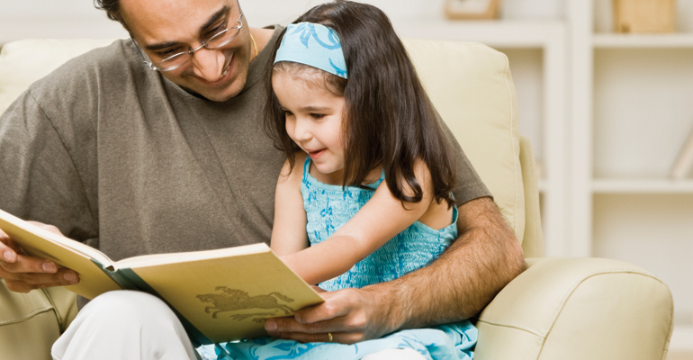 Father reading with his daughter to ward off language impairment