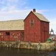 A red building on the water, representing Massachusetts adoption laws and policies