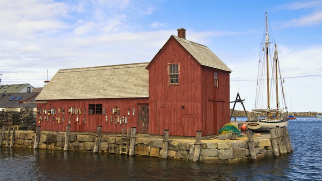 A red building on the water, representing Massachusetts adoption laws and policies