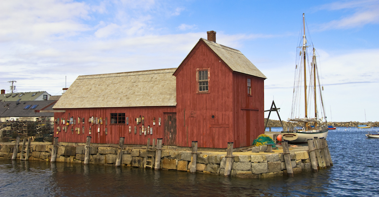 A red building on the water, representing Massachusetts adoption laws and policies