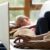 An adoption social worker uses her laptop while her daughter naps on the couch.