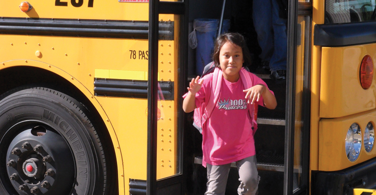 A child getting off a school bus, prepared to discuss race in the classroom