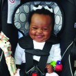 A baby in a car seat happy about childproofing