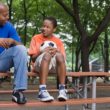 Parenting teens: a dad sits outside with his son at a picnic table