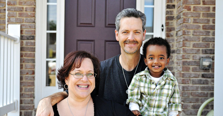 A family sitting together happily after accepting an adoption referral