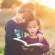 Two girls read about their birth culture together