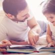A dad works on building reading skills with his daughter by reading a book together.
