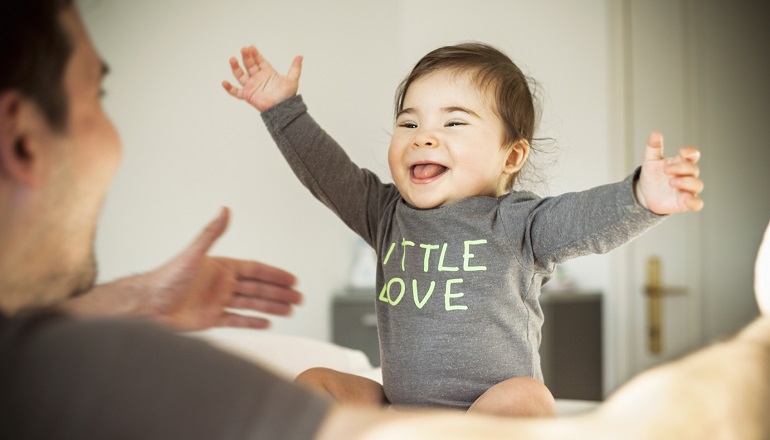 A smiling baby, progressing through the stages of infant development