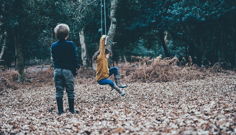 Two siblings play together in the yard after being adopted.