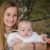 A teen sister holds her new sibling baby brother in the park