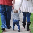 A newly formed family walking down the street, after the parents successfully navigated realtionships with expectant mothers